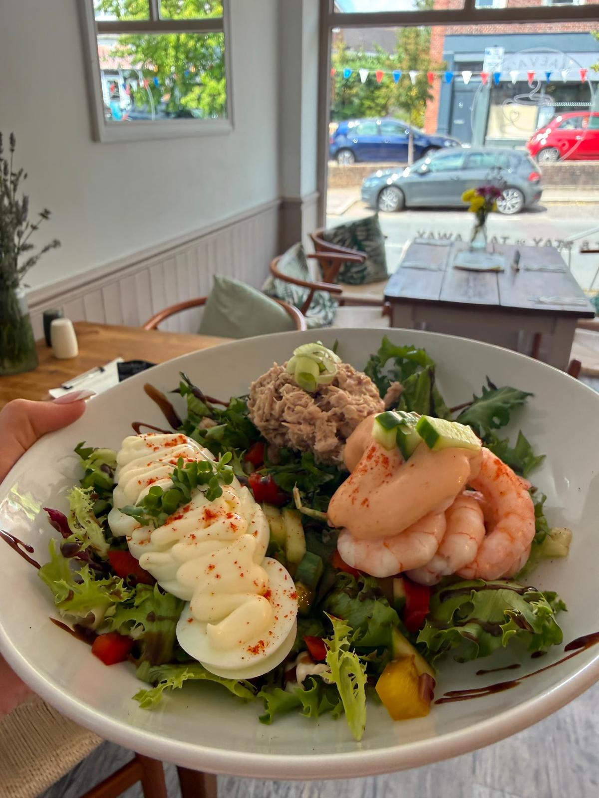 Prawn, tuna and egg salad bowl by the window